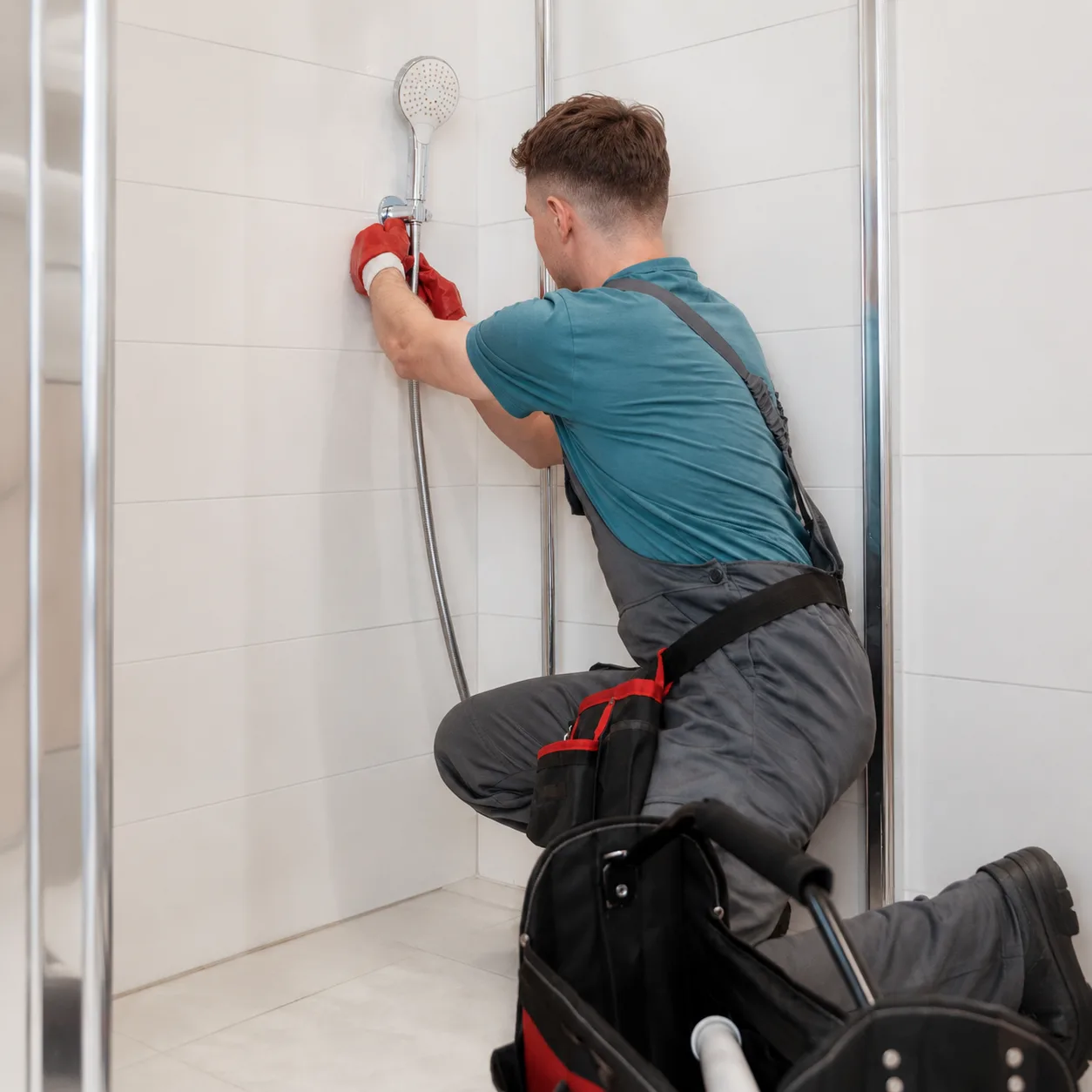 Handwerker von Fix & Form montiert eine Handbrause in einer bodengleichen Dusche